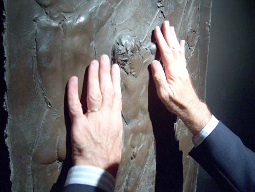 lettura tattile del bassorilievo in bronzo Deposizione (1947-1966) da parte di Aldo Grassini