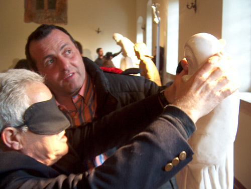 Felice Tagliaferri guida alla lettura tattile di una sua scultura un vistatore bendato