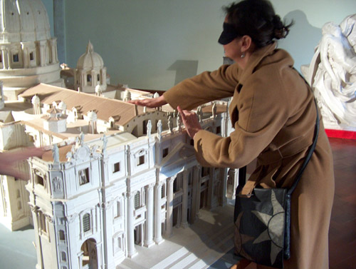 Una visitatrice bandata esplora il modellino della basilica di San Pietro