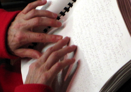 Mani leggono il testo in Braille