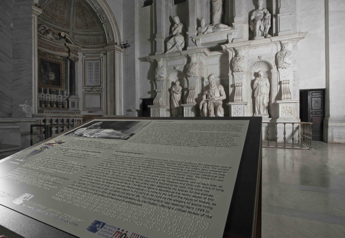 La tomba di Giulio II e una pannello esplicativo in nero e Braille