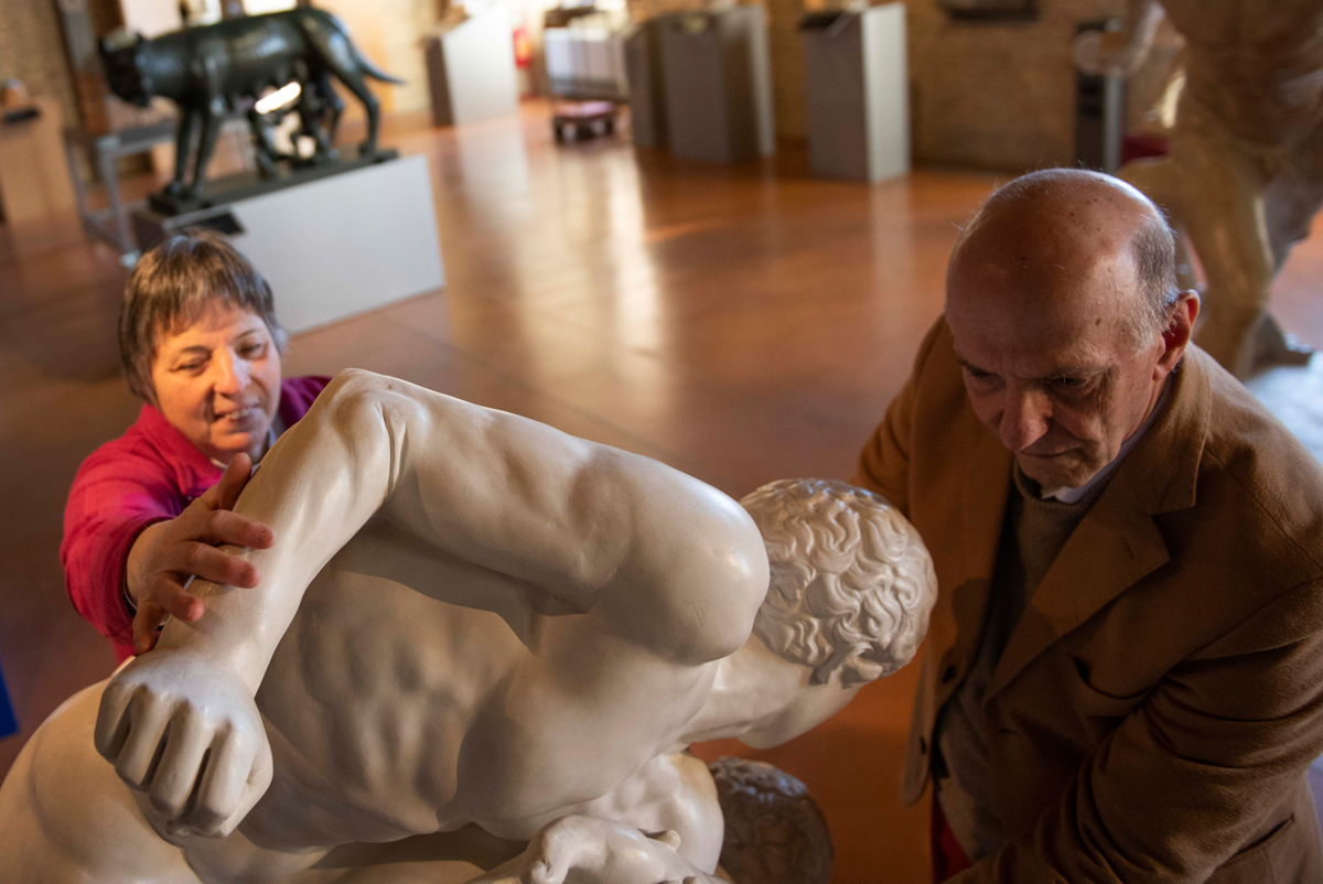 Aldo Grassini and Daniela Bottegoni touching an artwork