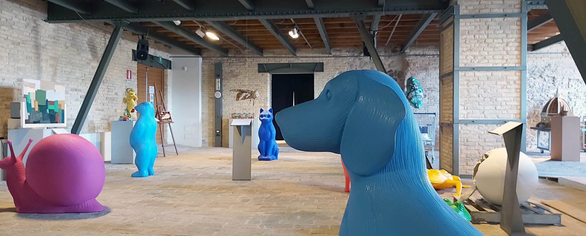 panoramica sala mostra con cane azzurro in plastica